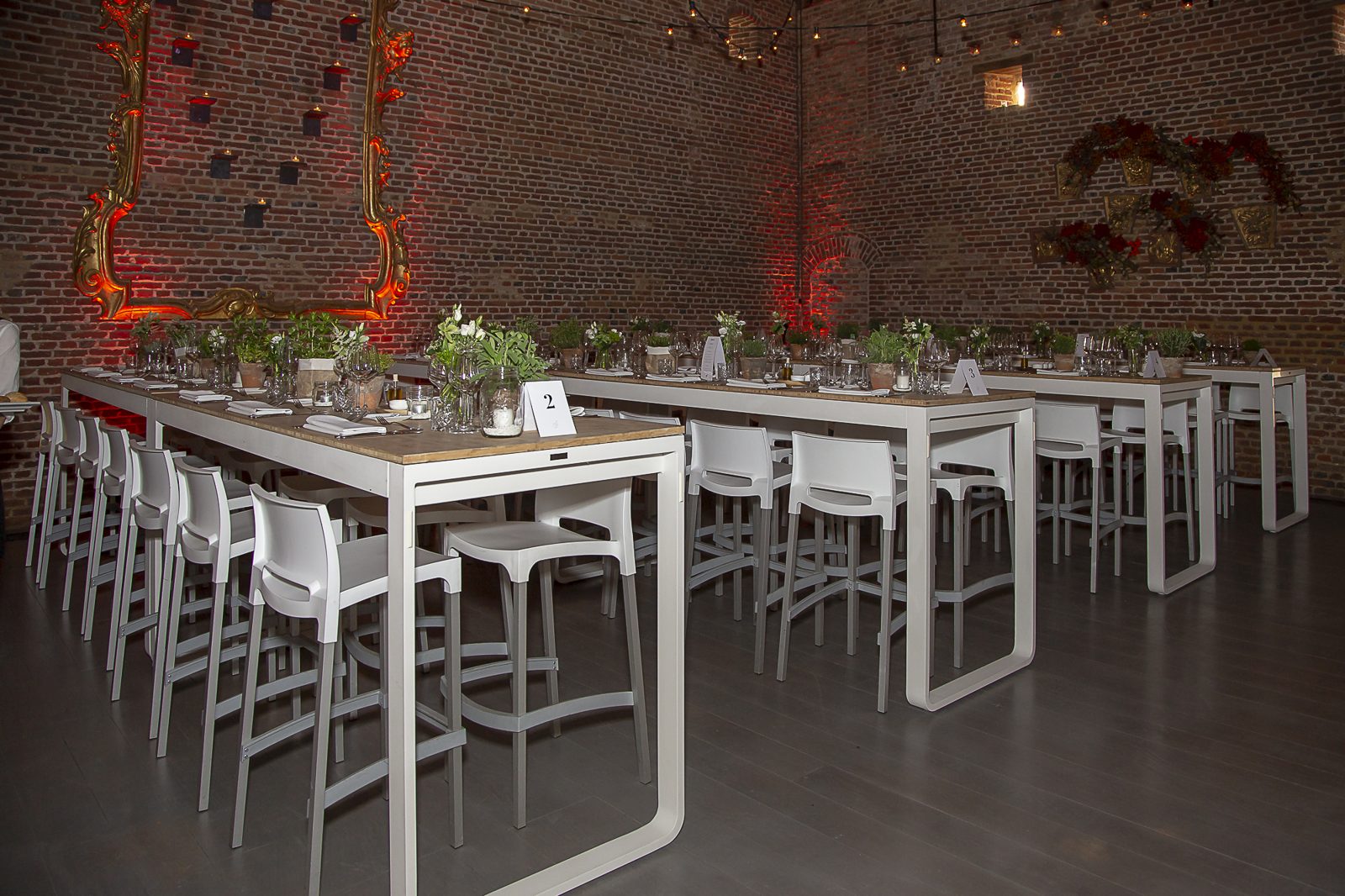 Lange tafels met subtiele bloemaccenten in een sfeervolle zaal