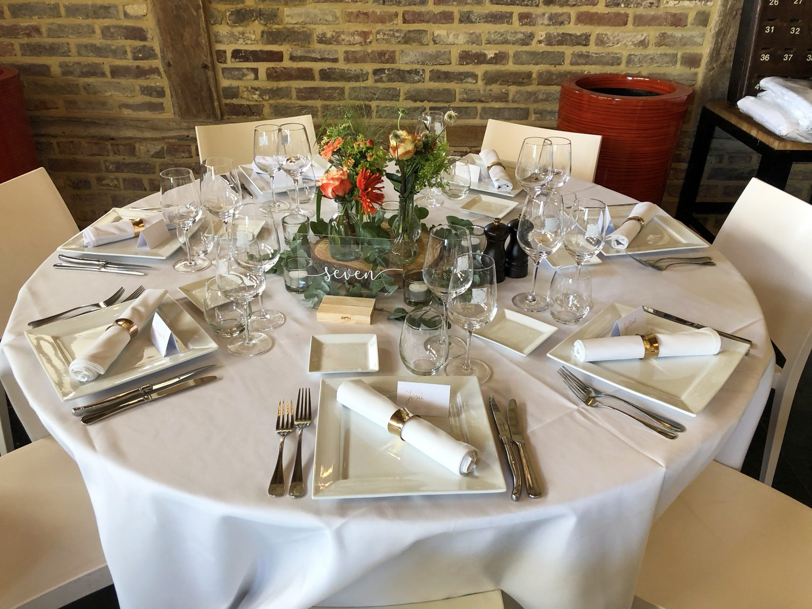 Ronde feesttafel met laag bloemstuk in warme tinten