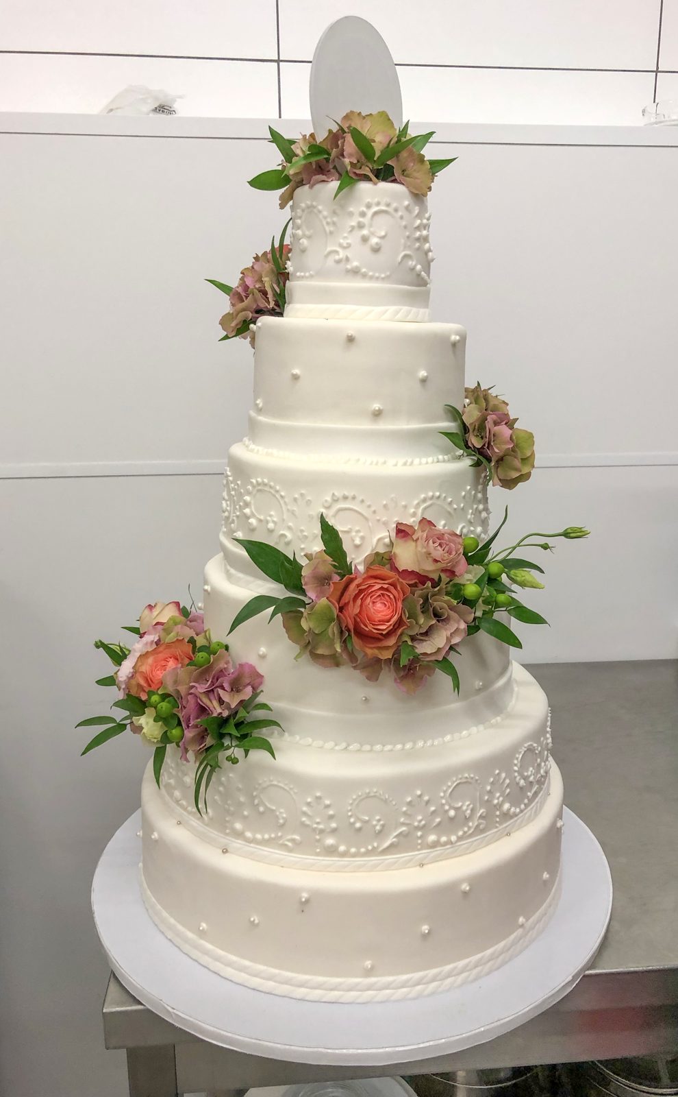 Bruidstaart met verse bloemen tussen de lagen