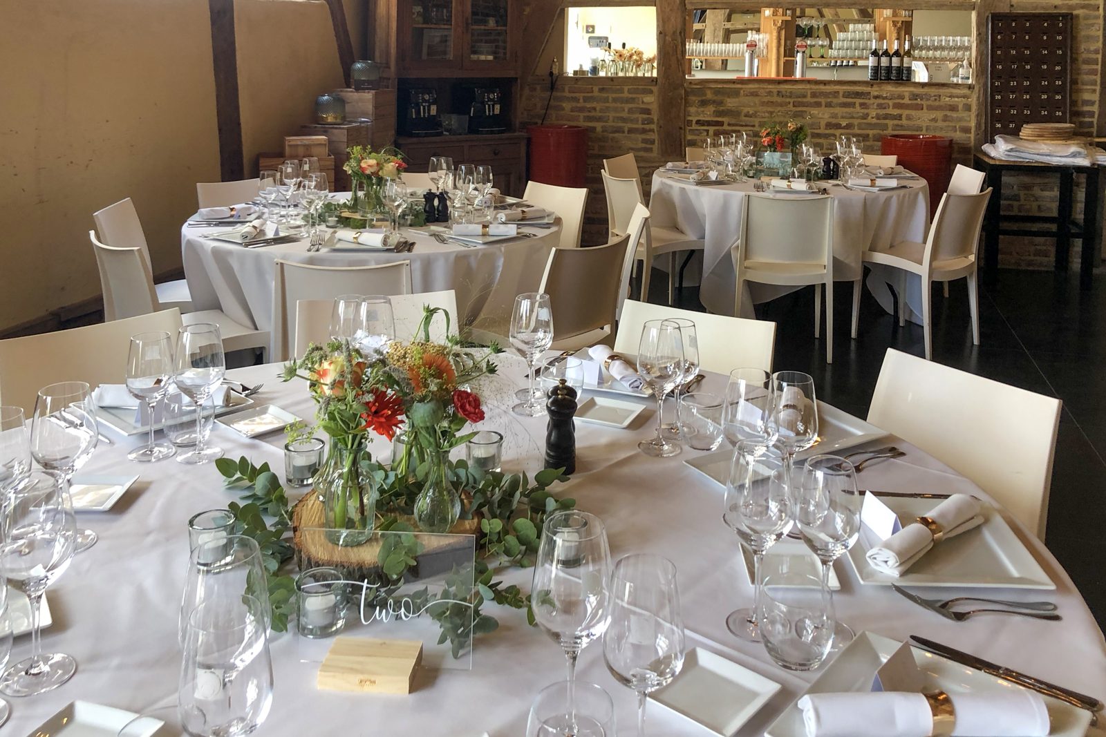 Feestzaal met natuurlijke bloemstukken op elke tafel